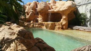 una piscina con cascata e scivolo d'acqua di Hospedaje solymar III Sarie Bay a San Andrés