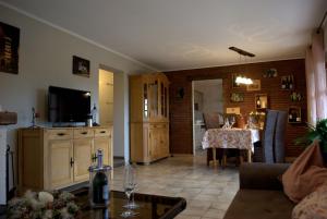 a living room with a couch and a table with a television at CasaVitis "Erholung am Weinberg" in Lontzen
