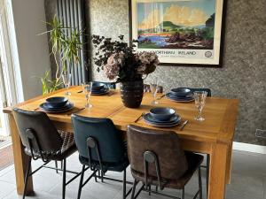 a wooden table with chairs and a vase of flowers at Loughshore, Large Detached House, Jordanstown in Newtownabbey