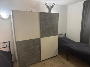 a bedroom with a bed and a partition with a deer on top at BaumTraum in Fürthen