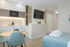 a kitchen and dining room with a table and chairs at Calvário Suites III in Chaves