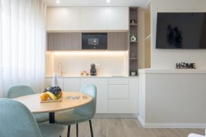 a kitchen with a table with a bowl of fruit on it at Calvário Suites III in Chaves