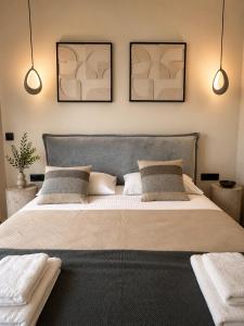 a bedroom with a large bed with two pictures on the wall at Noema Park View in Xanthi