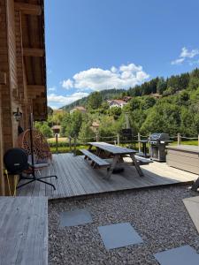 a deck with a picnic table and a bench at Chalet Tramontane, gîte tout confort in Xonrupt-Longemer