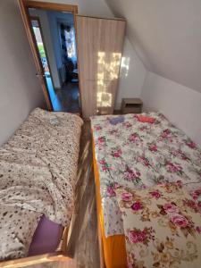 two beds in a small room with flowers at Domek Rosa in Bachlowa