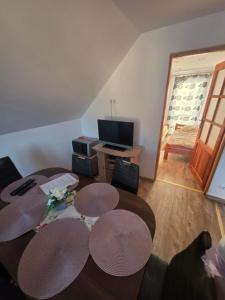 a living room with a table and a television at Domek Rosa in Bachlowa