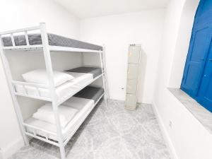a white bunk room with white shelves and a blue door at Casa Mykonos Rio in Rio de Janeiro