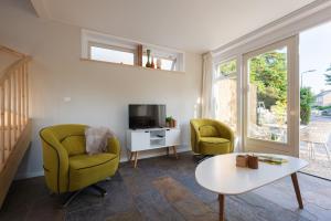a living room with two chairs and a tv at Kortbie Zee in Biggekerke