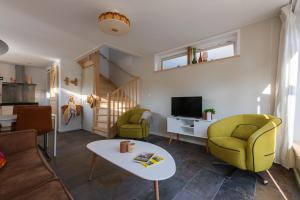 a living room with a couch and chairs and a table at Kortbie Zee in Biggekerke