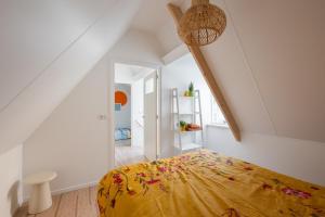 a bedroom with a bed with a yellow blanket at Kortbie Zee in Biggekerke