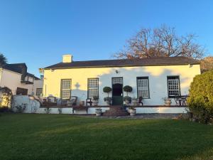 a white house with chairs and a yard at Rose Cottage De Hoop Farm PAARL SOUTH in Hartebeeskraal