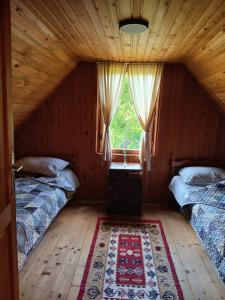 a attic room with two beds and a window at Vikendica ZORA in Foča
