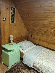 a bedroom with two beds in a wooden room at Vikendica ZORA in Foča