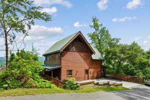 a small wooden cabin with benches in front of it at The Honeymoon Sweet #63 by Venture Smoky Mountains in Sevierville