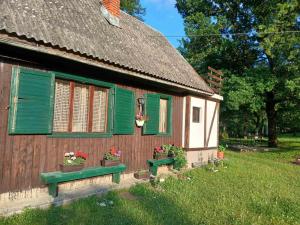 a house with green shutters and a bench in front of it at Vikendica ZORA in Foča