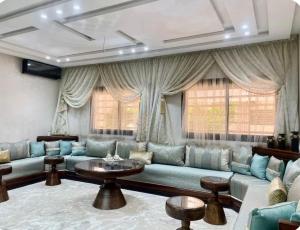 a living room with a blue couch and windows at Fes Golf Residence in Fez