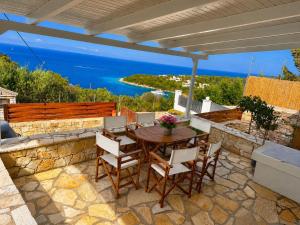 a patio with a table and chairs and the ocean at Porto Vigla in Tranakatika +8 photos