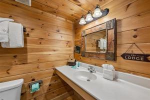 a bathroom with a sink and a mirror at The Honeymoon Sweet #63 by Venture Smoky Mountains in Sevierville +76 photos