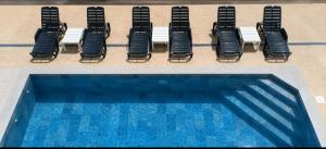 a row of chairs next to a swimming pool at Rooms M2 in Trebinje