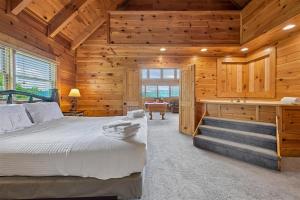 a bedroom in a log cabin with a bed and a desk at The Honeymoon Sweet #63 by Venture Smoky Mountains in Sevierville