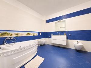 a blue and white bathroom with a tub and toilet at Vila Panorama - Bunloc in Săcele +23 photos