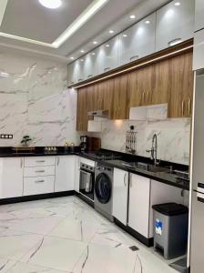a large kitchen with white appliances and marble walls at Fes Golf Residence in Fez