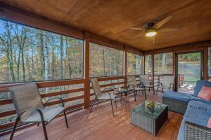 a screened in porch with chairs and tables at Creekview Cabin - Hot Tub, EV Station, Pet Friendly, Screen Porch, Wifi, Grill, Fire Pit, Deck, Family Friendly, Game Room, King Bed in Morton Grove