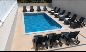 a group of chairs and a swimming pool with a bunch ofitures at M2 Sobe in Trebinje +18 photos