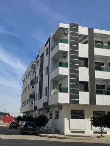 a large apartment building with cars parked in front of it at Fes Golf Residence in Fez
