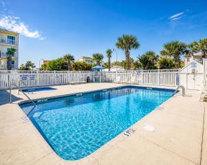 a swimming pool with a white fence and palm trees at Ocean Towers Resort in Myrtle Beach