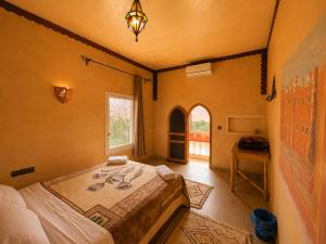 a bedroom with a large bed and a window at Auberge Restaurant Zahra in Boumalne Dades +32 photos