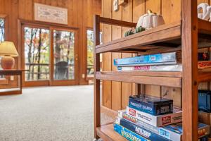 a stack of books on a shelf in a room at Haven Home - Deck, Grill, Hiking, Pool Access, Games, Community Playground and Tennis Courts in Berkeley Springs
