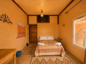 a bedroom with two beds in a room with a window at Auberge Restaurant Zahra in Boumalne Dades