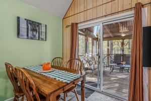 a dining room with a table and chairs and a patio at Trails End River Retreat - Riverside in Berkeley Springs