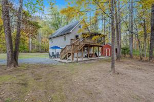 a large white house with a gambrel roof with a wooden deck at Trails End River Retreat - Riverside in Berkeley Springs
