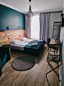 a bedroom with a bed and a chair and a desk at Karczma Kujawska in Inowrocław