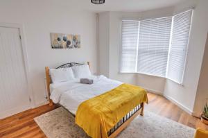 a bedroom with a bed with a yellow blanket on it at Modern Family & Contractor Home - Free Parking - Garden - Sleeps 6 - Fast WiFi - in Bristol