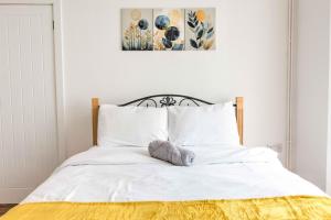a bed with white sheets and a stuffed animal on it at Modern Family & Contractor Home - Free Parking - Garden - Sleeps 6 - Fast WiFi - in Bristol +19 photos