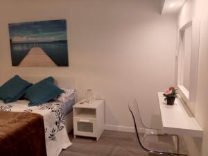 a bedroom with a bed and a table and a painting at Estudios 71 Sardinero RH - Santander in Santander