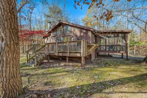 a home with a large deck and a tree at Woods Song -- Hot Tub - Pet Friendly - Wifi - King Bed - Woods Resort - Golf Nearby - Pool Pass - Spa - Grill - Fireplace in Hedgesville