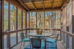 a screened in porch with a table and chairs at Woods Song -- Hot Tub - Pet Friendly - Wifi - King Bed - Woods Resort - Golf Nearby - Pool Pass - Spa - Grill - Fireplace in Hedgesville