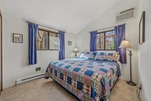 a bedroom with a bed and two windows at Woods Song -- Hot Tub - Pet Friendly - Wifi - King Bed - Woods Resort - Golf Nearby - Pool Pass - Spa - Grill - Fireplace in Hedgesville +80 photos