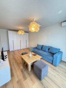 a living room with a blue couch and a table at ThePlaceToBe2 in Brăila