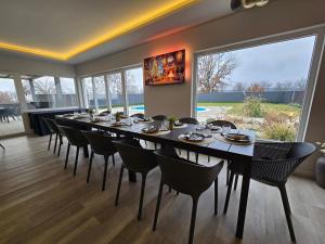 a dining room with a long table and chairs at Casa Cordis in Korduševci
