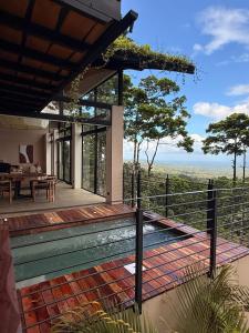 a house with a deck with a view at Origins Astral in Bagaces