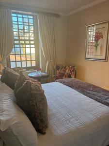 a bedroom with a large bed and a window at Rose Cottage De Hoop Farm PAARL SOUTH in Hartebeeskraal +32 photos