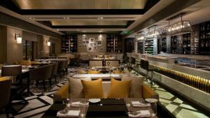 a restaurant with couches and tables and a bar at Hotel DSR Krone New Delhi in New Delhi