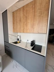 a kitchen with a sink and wooden cabinets at Serenity Seaview Suite Przno in Pržno