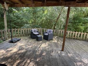 two chairs on a wooden deck with a fence at BaumTraum in Fürthen