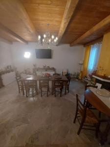 a dining room with a table and chairs and a chandelier at Bed and Breakfast Aida in Cotignola